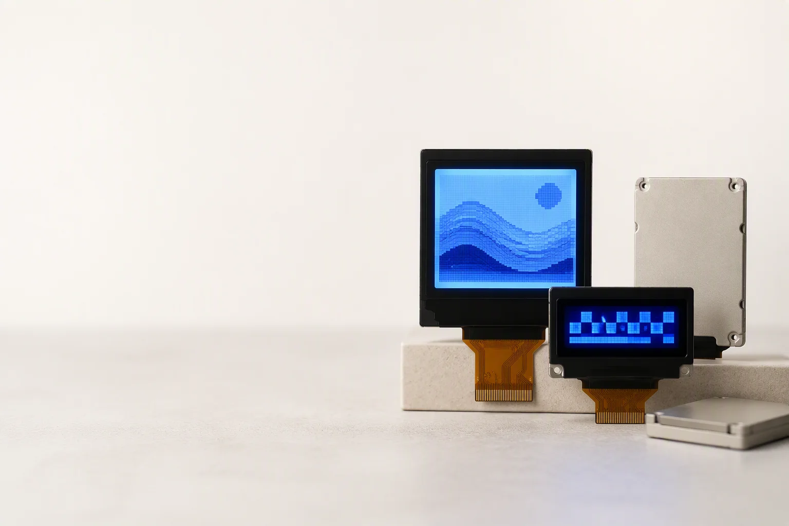 Monochrome COG LCD modules, a 16×2 character and a 128×64 graphic with blue backlight, arranged on a lab bench